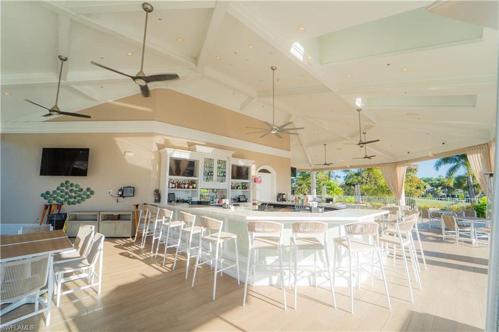 8457 Radcliffe Terrace, Unit 102 Naples, FL 34120 - Photo 24 of 33 Kitchen featuring a kitchen bar, a large island, vaulted ceiling, and recessed lighting