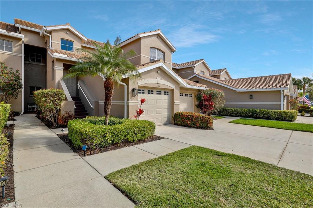 8457 Radcliffe Terrace, Unit 102 Naples, FL 34120 - Photo 3 of 33 Mediterranean / spanish-style house with stucco siding, a garage, concrete driveway, a tiled roof, and a front yard