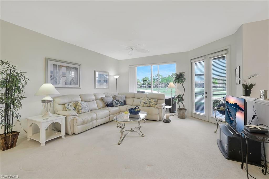 8457 Radcliffe Terrace, Unit 102 Naples, FL 34120 - Photo 5 of 33 Living area with light carpet, french doors, and a ceiling fan