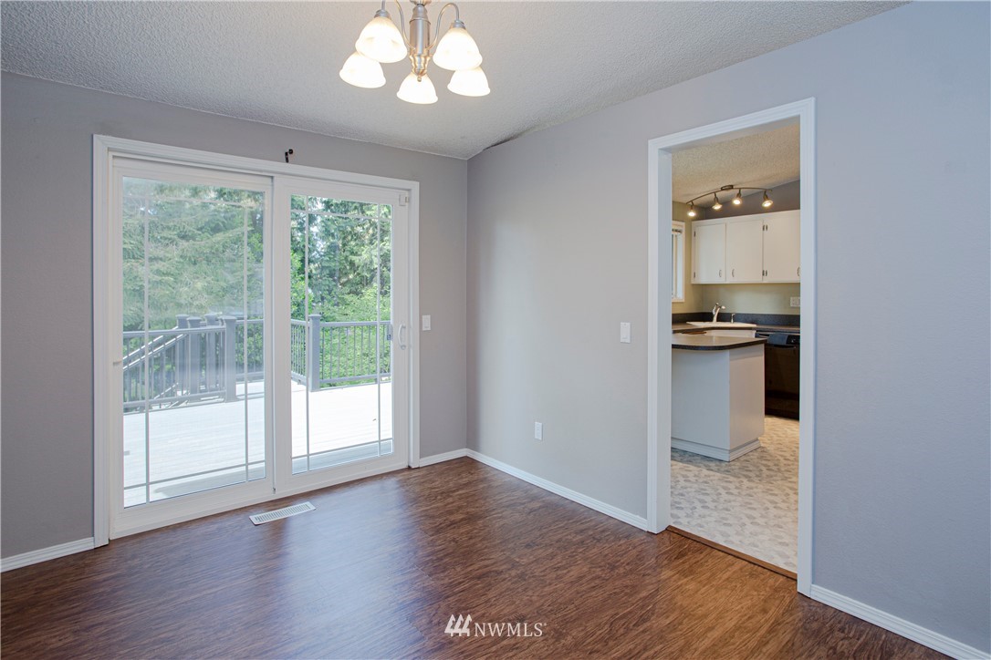 17522 Brook Boulevard Bothell, WA 98012 - Photo 4 of 35 an empty room with wooden floor cabinet and windows