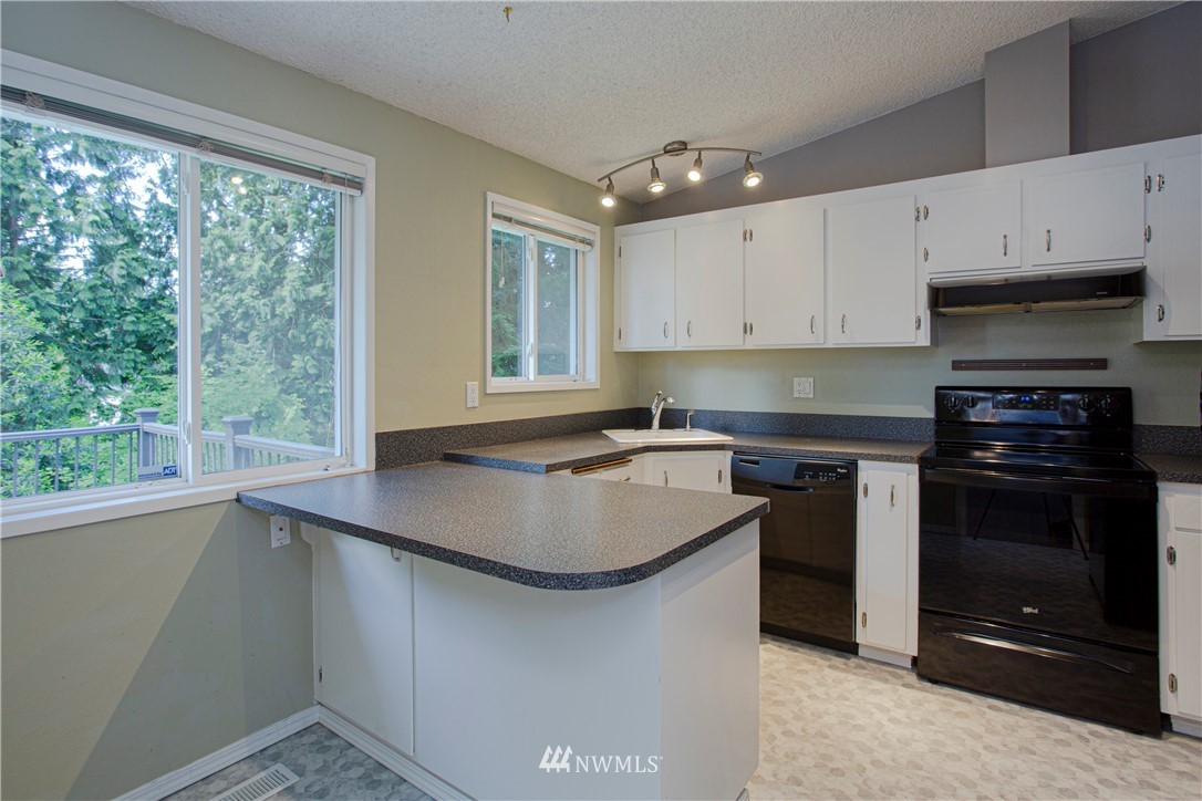 17522 Brook Boulevard Bothell, WA 98012 - Photo 5 of 35 a kitchen with stainless steel appliances granite countertop a sink stove and a refrigerator