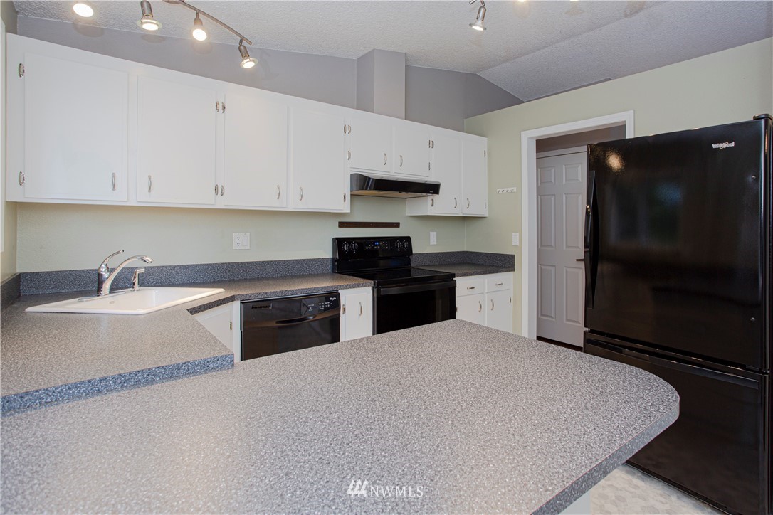 17522 Brook Boulevard Bothell, WA 98012 - Photo 6 of 35 a kitchen with granite countertop a stove sink and cabinets