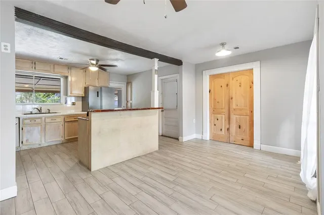 a view of a kitchen with wooden floor and electronic appliances