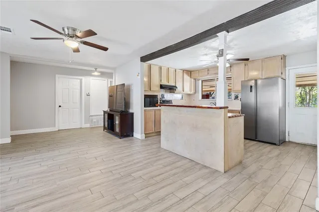 a kitchen with stainless steel appliances kitchen island granite countertop a refrigerator and a stove
