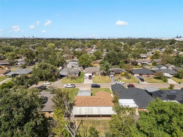 an aerial view of residential houses with outdoor space and trees