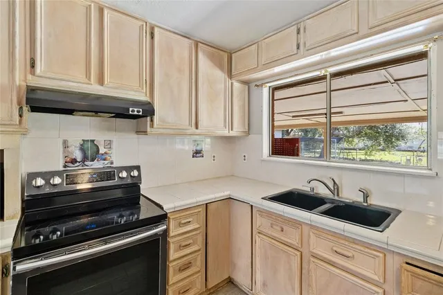 a kitchen with stainless steel appliances a sink a stove and cabinets