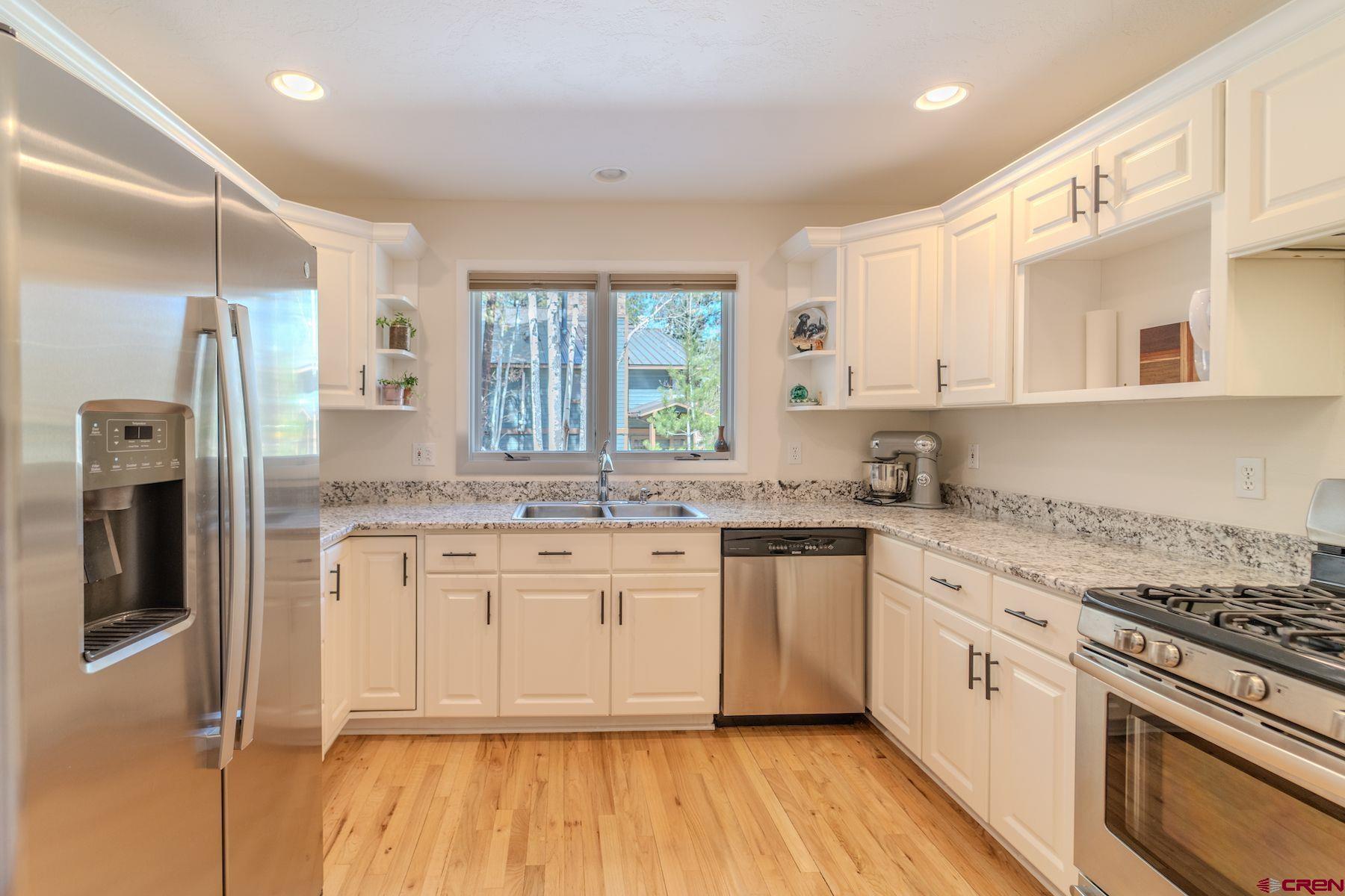 34 Crocus Court Durango, CO 81301 - Photo 7 of 30 a kitchen with stainless steel appliances granite countertop a stove a sink dishwasher a refrigerator and white cabinets with wooden floor
