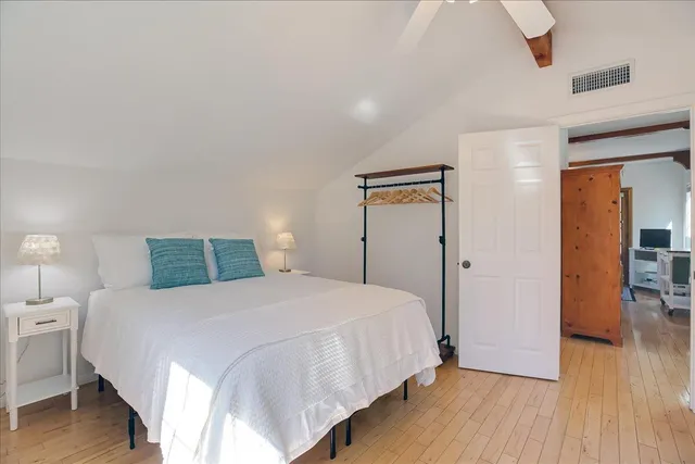 a bedroom with a bed and wooden floor