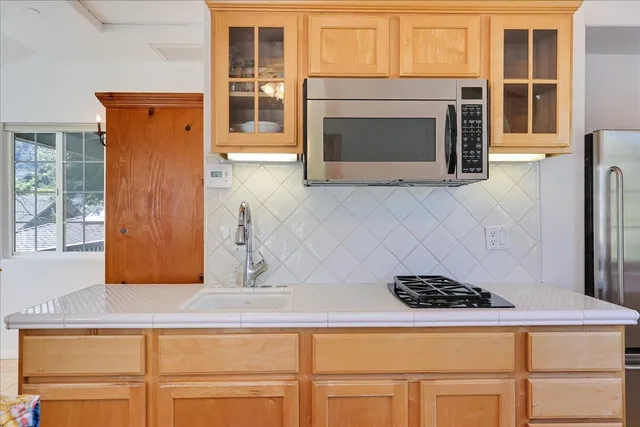 a kitchen with stainless steel appliances granite countertop a stove a microwave and a refrigerator