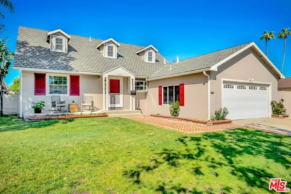 a front view of house with yard and outdoor seating