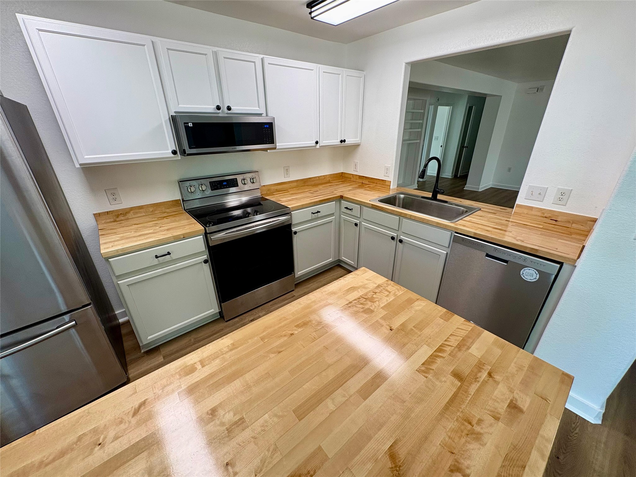 8003 Bannock Lane Austin, TX 78747 - Photo 10 of 40 Kitchen featuring butcher block countertops, stainless steel appliances, and dark wood-type flooring