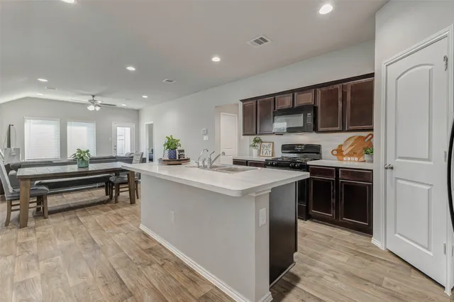 a kitchen with stainless steel appliances kitchen island granite countertop a stove and a refrigerator