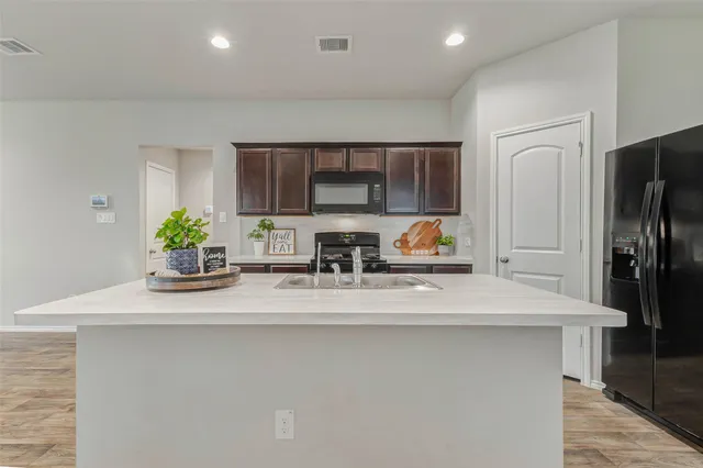 a kitchen with stainless steel appliances granite countertop a sink a refrigerator and a stove
