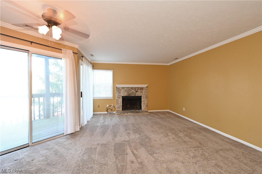 28140 Detroit Road, Unit A1 Westlake, OH 44145 - Photo 27 of 30 Unfurnished living room featuring light colored carpet, a fireplace, a wealth of natural light, and ceiling fan