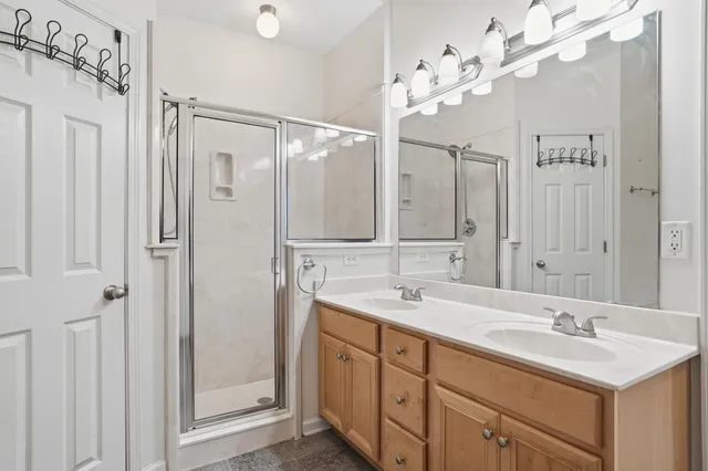 a bathroom with a double vanity sink mirror and shower