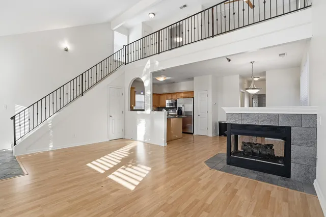 a view of a hallway with wooden floor a fireplace and entryway
