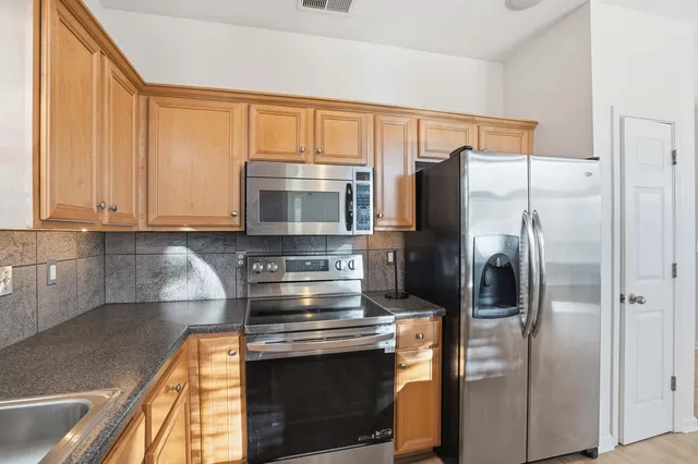 a kitchen with metallic refrigerator and cabinets