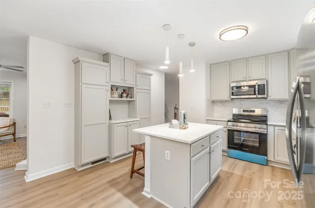 a kitchen with a sink stainless steel appliances and white cabinets