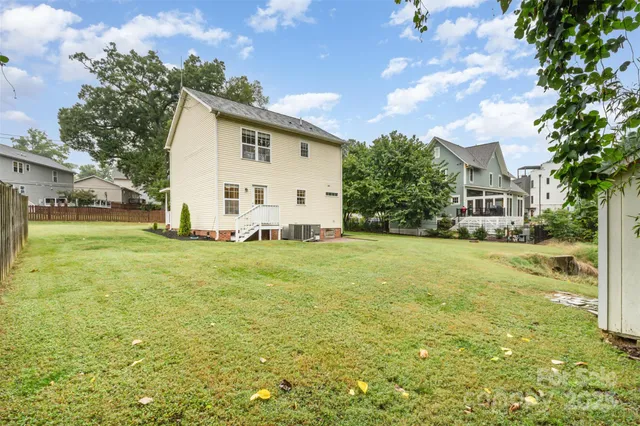 a view of a white house with a big yard and large trees