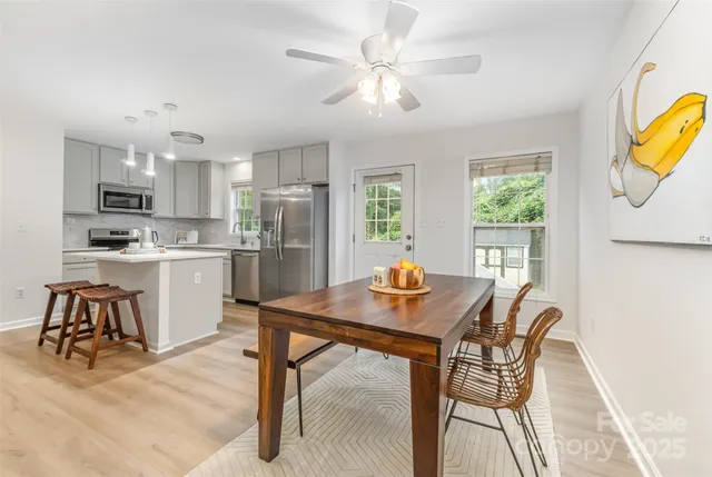a kitchen with a table chairs refrigerator and microwave