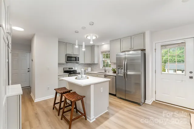 a kitchen with refrigerator cabinets and wooden floor