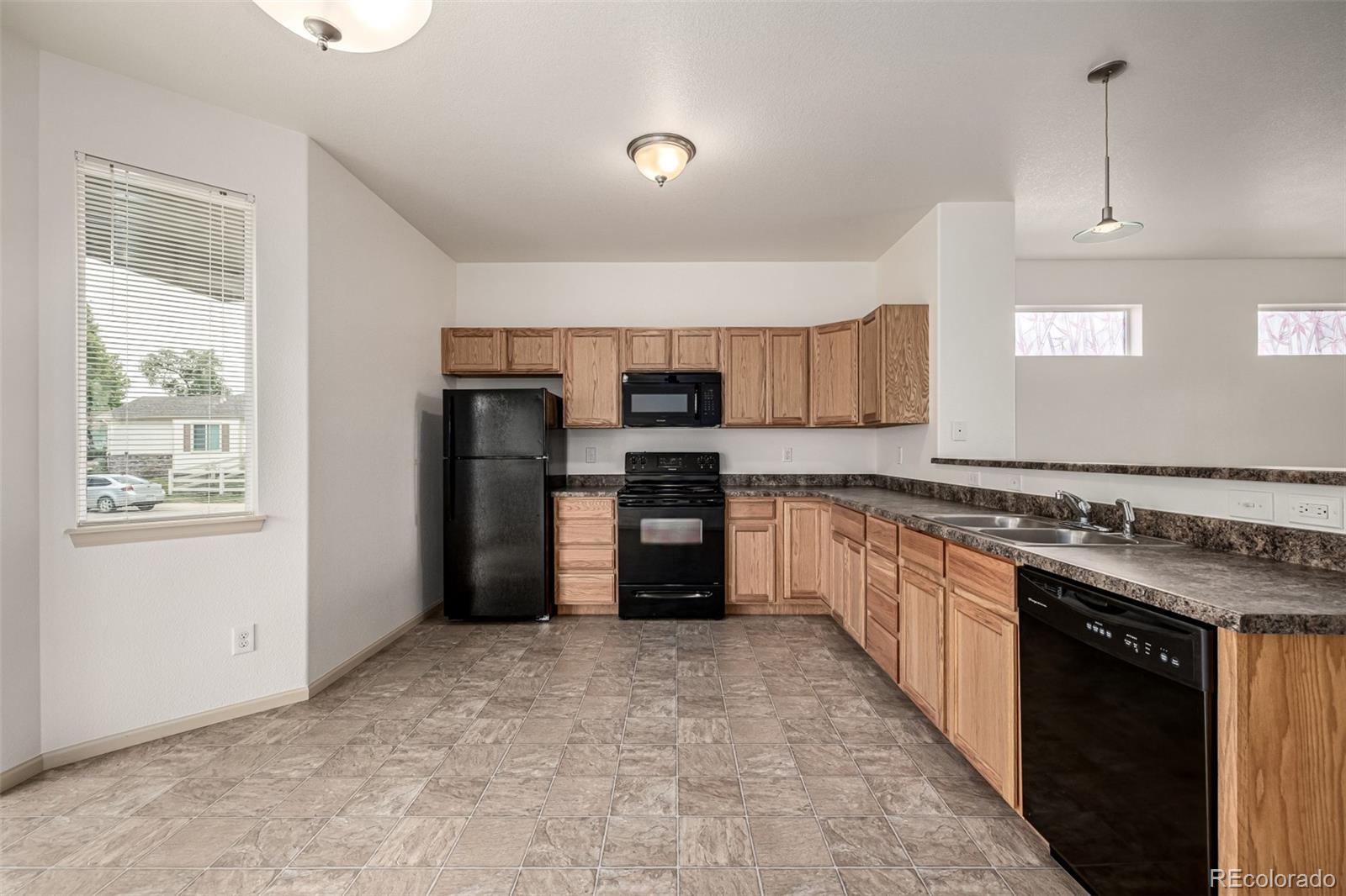 268 Naples Street Firestone, CO 80520 - Photo 11 of 34 a large kitchen with stainless steel appliances granite countertop a stove a sink and a refrigerator