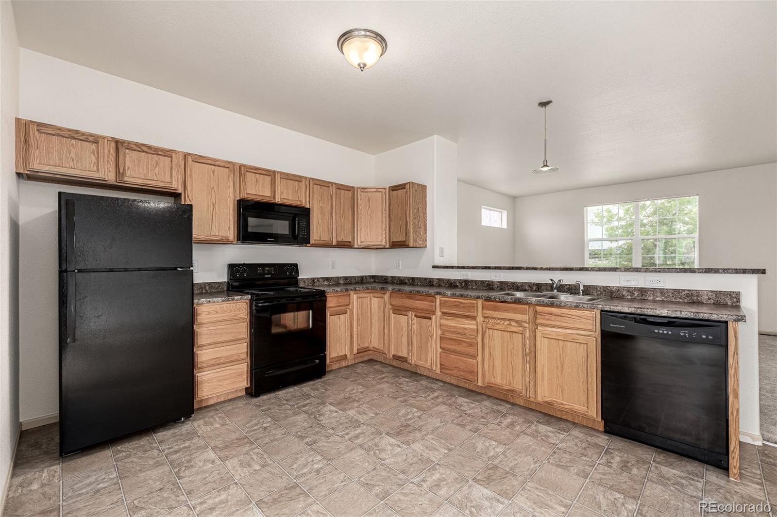 268 Naples Street Firestone, CO 80520 - Photo 12 of 34 a kitchen with granite countertop a refrigerator stove top oven and sink