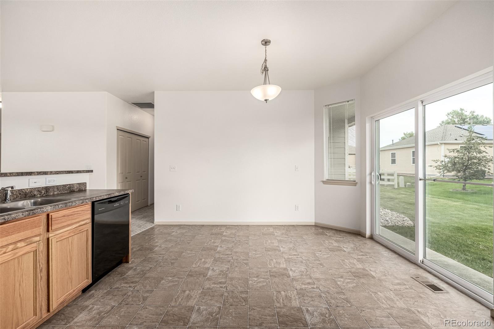 268 Naples Street Firestone, CO 80520 - Photo 14 of 34 a view of a kitchen with a sink and dishwasher with wooden floor