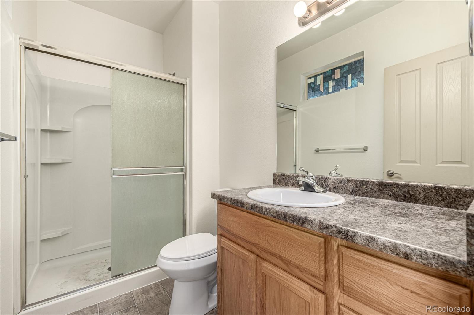 268 Naples Street Firestone, CO 80520 - Photo 18 of 34 a bathroom with a granite countertop sink toilet and shower