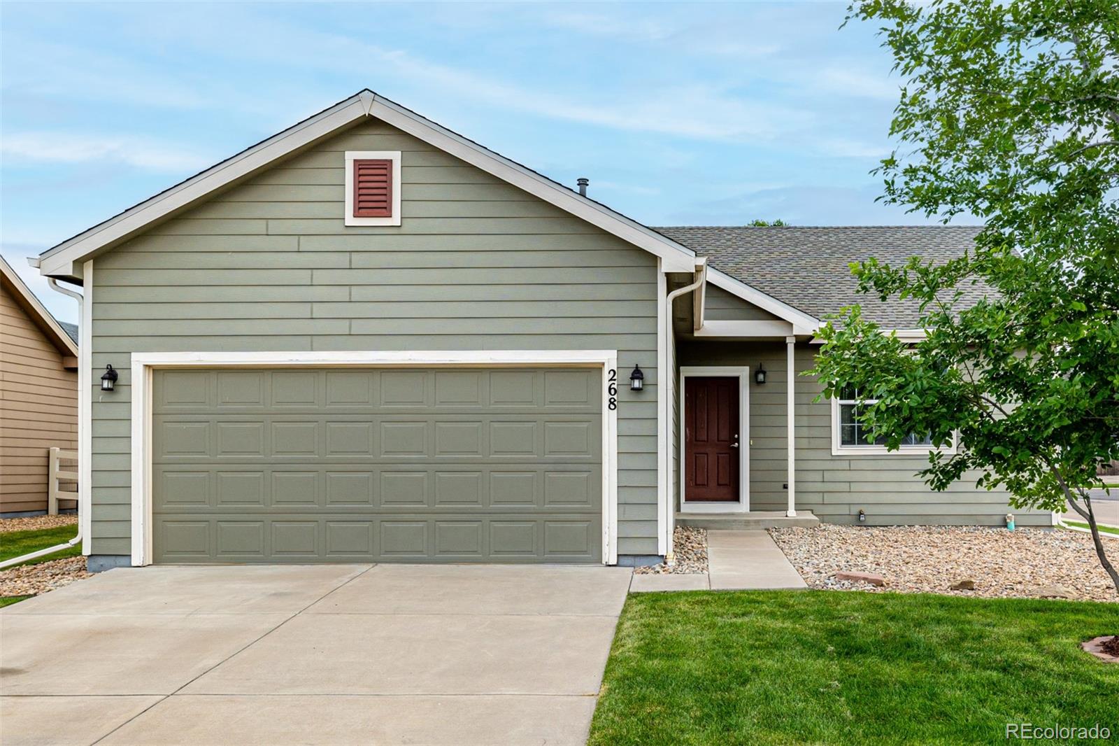 268 Naples Street Firestone, CO 80520 - Photo 2 of 34 a front view of a house with a yard and garage