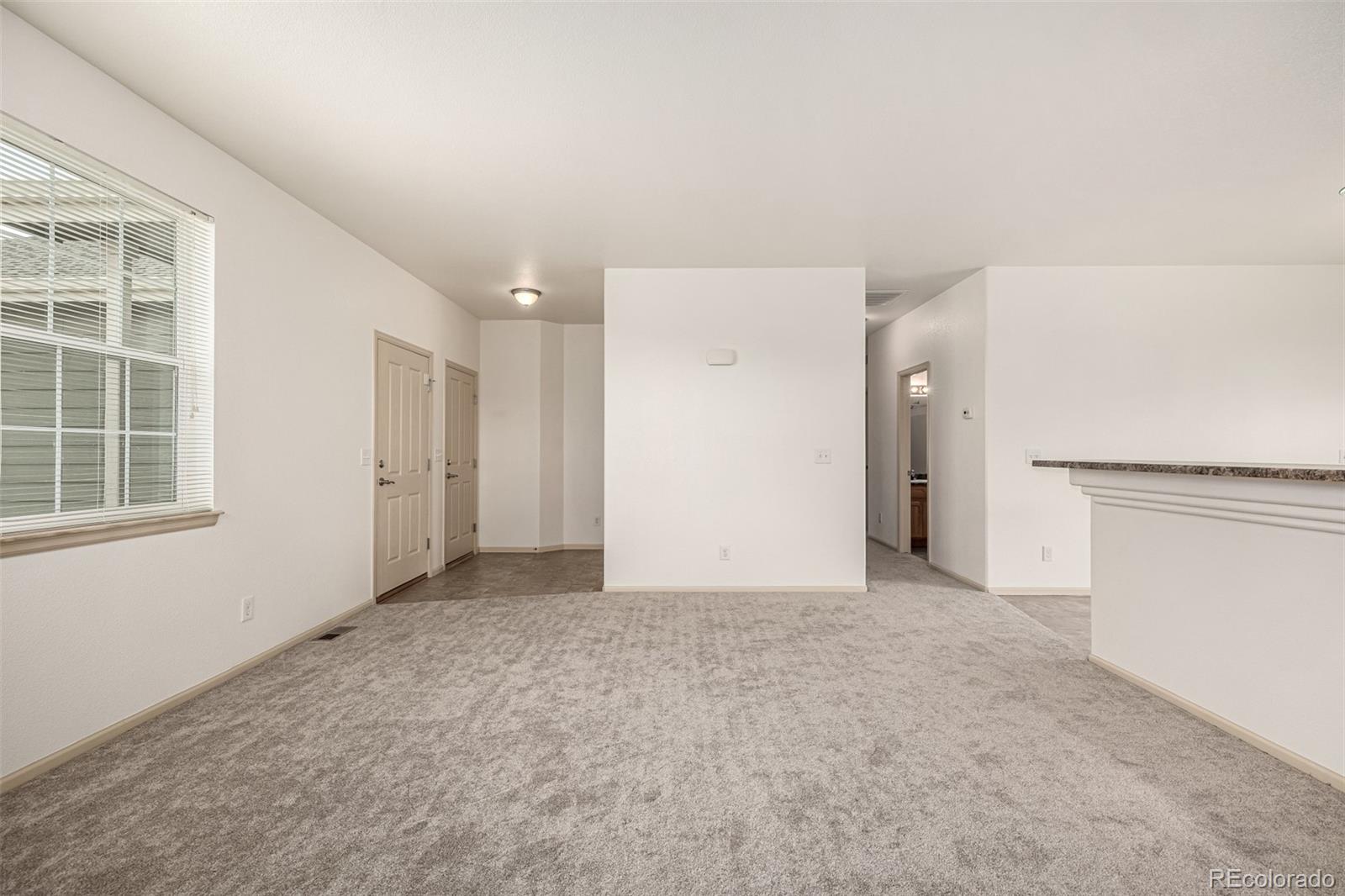 268 Naples Street Firestone, CO 80520 - Photo 7 of 34 an empty room with windows