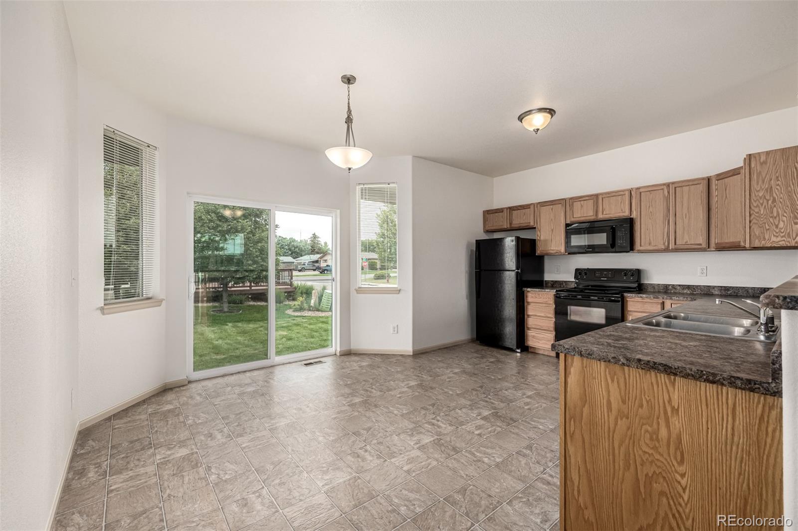 268 Naples Street Firestone, CO 80520 - Photo 9 of 34 a view of a kitchen with microwave and stove