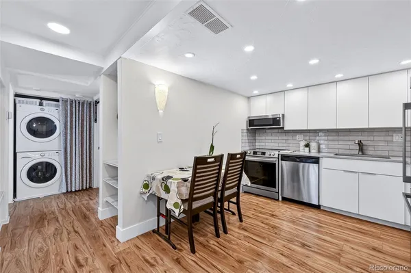 a kitchen with stainless steel appliances granite countertop a refrigerator a stove top oven a sink and cabinets