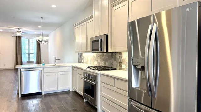 a kitchen with stainless steel appliances a refrigerator sink and microwave