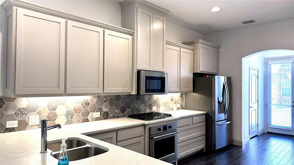 4683 B Rhett Lane Carrollton, TX 75010 - Photo 3 of 21 a kitchen with stainless steel appliances granite countertop a stove and a refrigerator