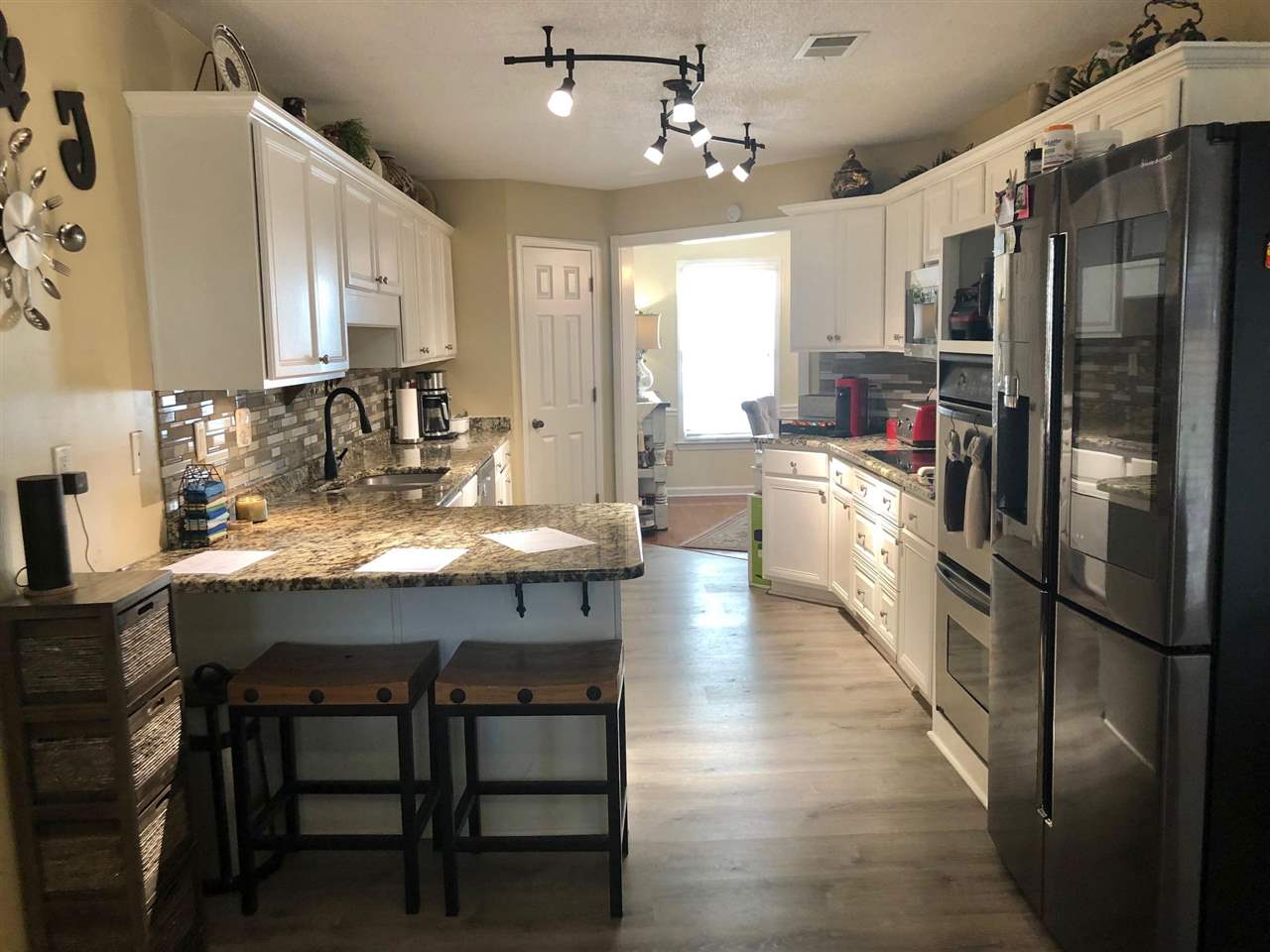 9114 Raspberry Lane Cordova, TN 38016 - Photo 4 of 22 a kitchen with stainless steel appliances granite countertop a refrigerator a sink dishwasher a stove and white cabinets with wooden floor