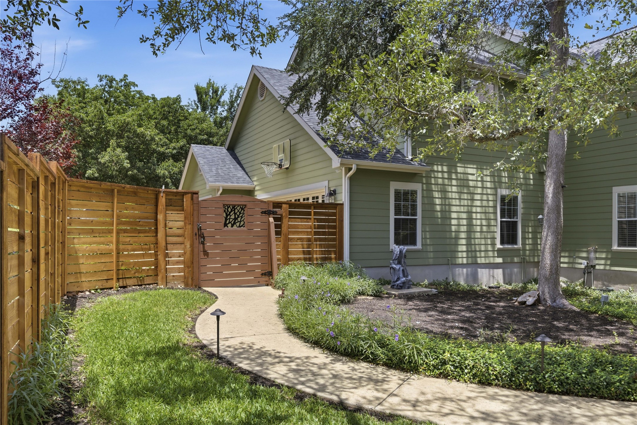 1204 Orlando Road Austin, TX 78733 - Photo 26 of 40 A graceful curved walkway guides to a private wooden fence enclosing the side yard.