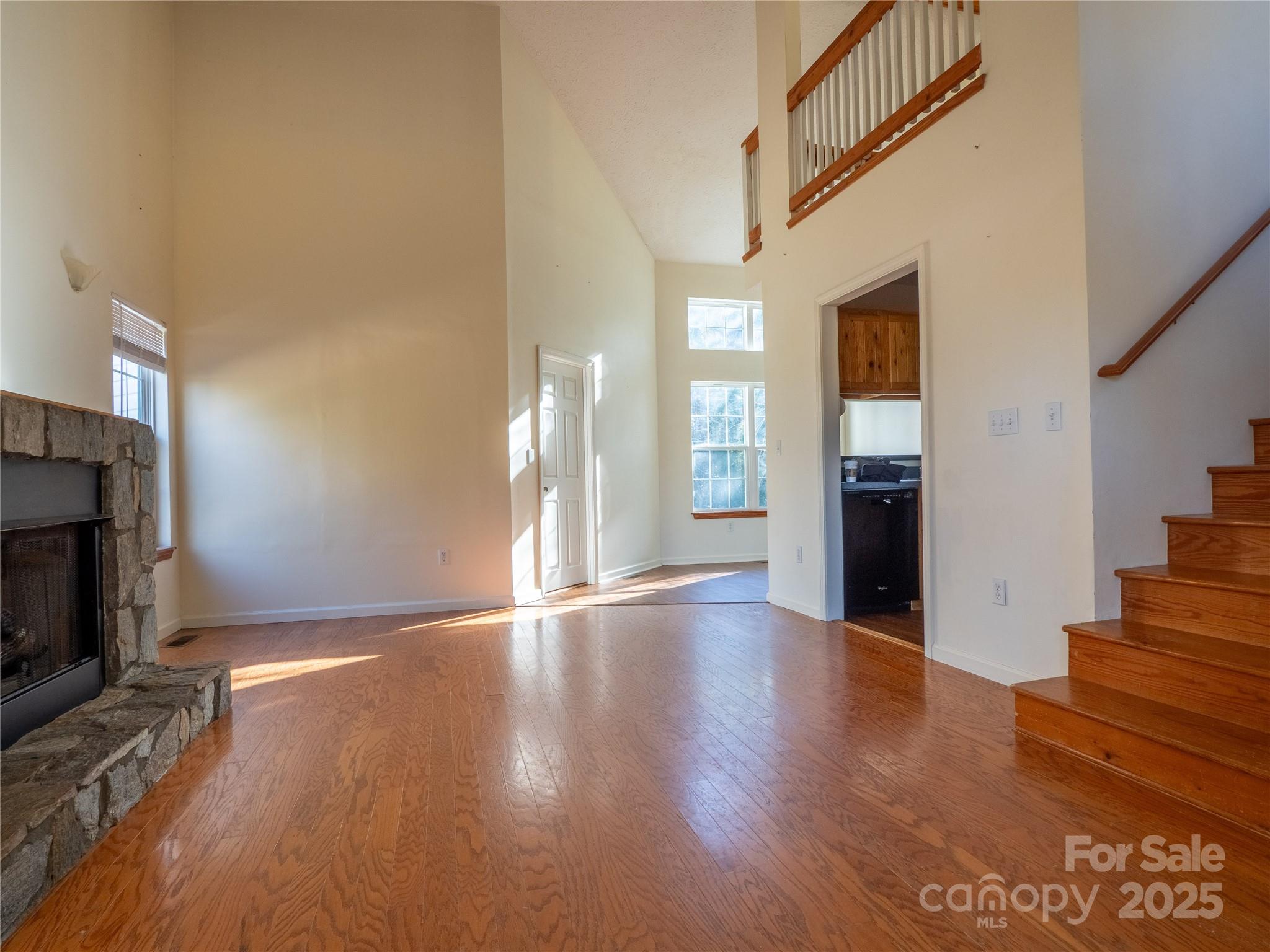 488 Oleta Road Hendersonville, NC 28792 - Photo 4 of 27 a view of an empty room with wooden floor fireplace and a window