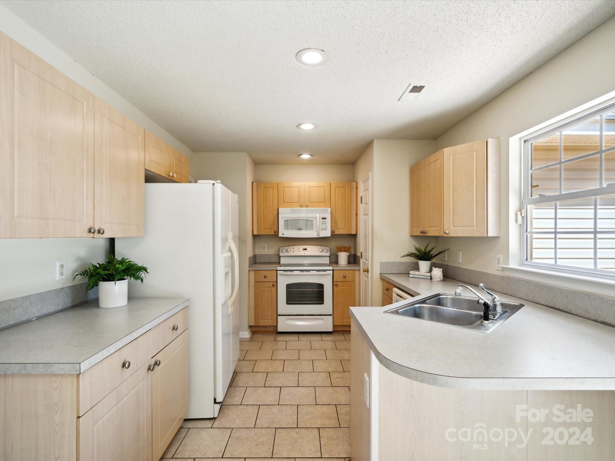 2113 River Chase Drive Monroe, NC 28110 - Photo 11 of 36 a kitchen with granite countertop a refrigerator and a sink