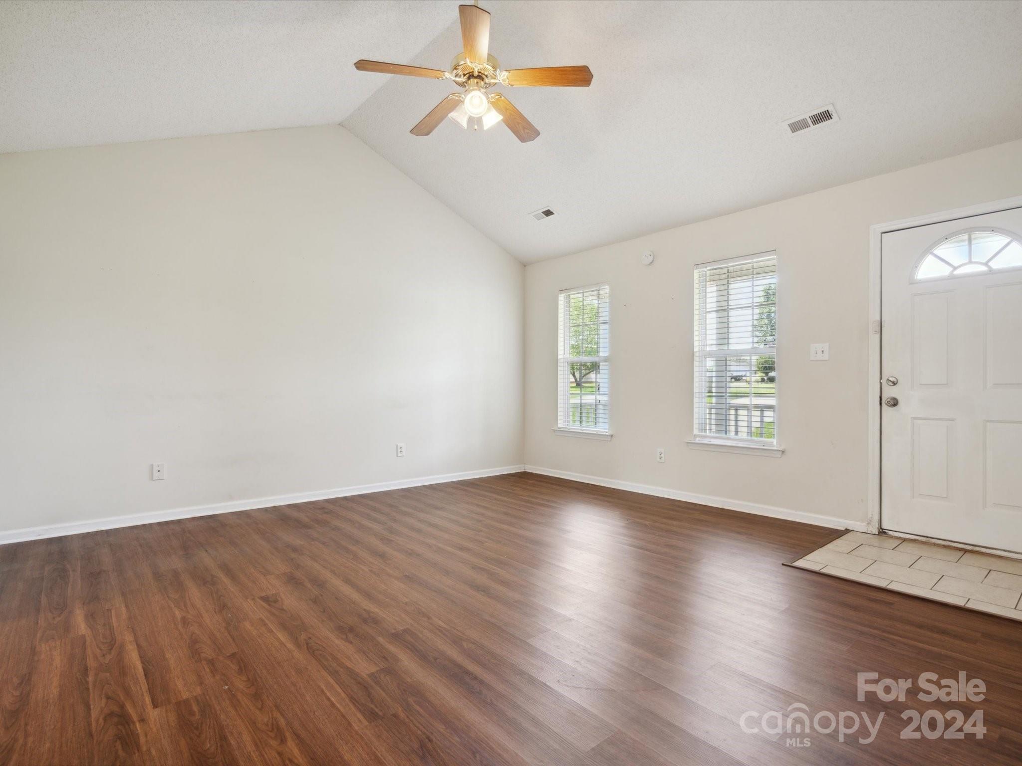 2113 River Chase Drive Monroe, NC 28110 - Photo 7 of 36 an empty room with wooden floor chandelier fan and windows