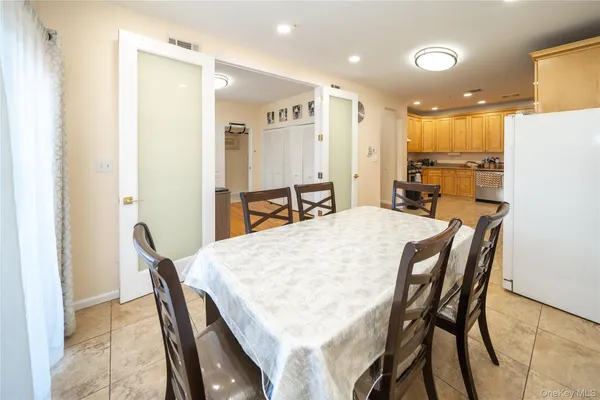 a dining room with furniture and a refrigerator