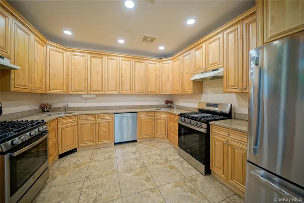 a kitchen with stainless steel appliances granite countertop a stove top oven sink and cabinets