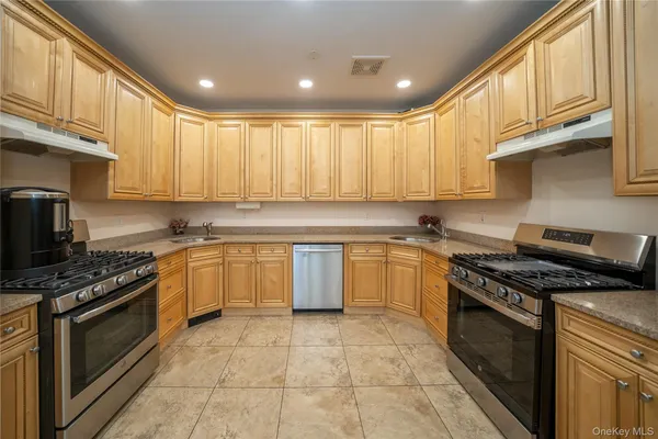 a kitchen with stainless steel appliances granite countertop a stove sink and cabinets