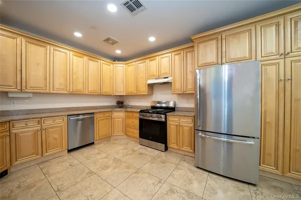 a kitchen with granite countertop stainless steel appliances a refrigerator cabinets and a sink