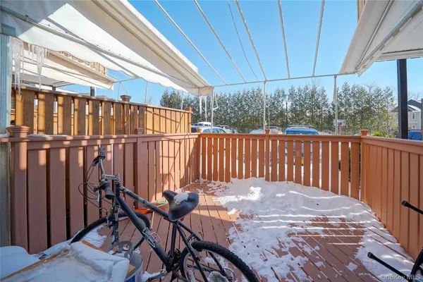 a view of a patio with table and chairs under an umbrella with wooden fence