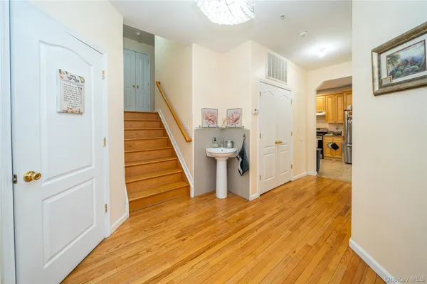 a view of a hallway with wooden floor and staircase