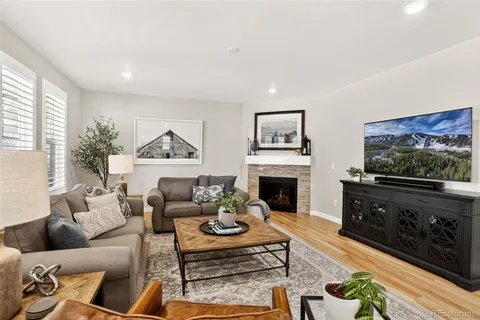 a living room with furniture a flat screen tv and a fireplace