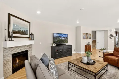 a living room with furniture a flat screen tv and a fireplace