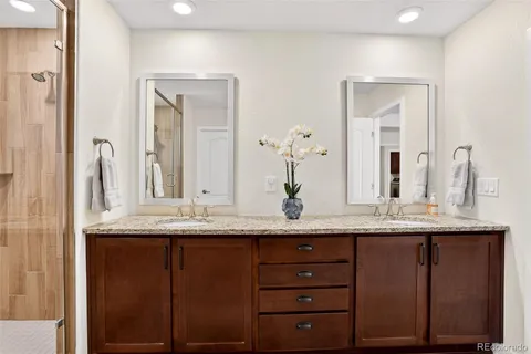 a bathroom with a granite countertop sink and a mirror