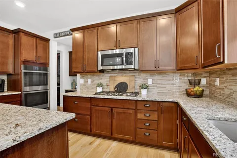 a kitchen with stainless steel appliances granite countertop a sink stove and refrigerator